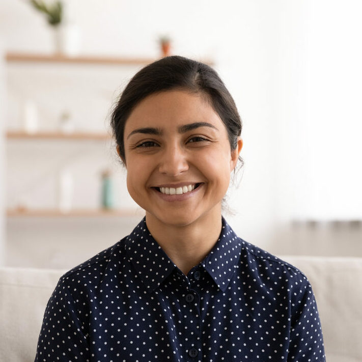 Portrait of smiling Indian woman creating video content with her webcam via Beings Portrait of smiling Indian woman creating video content with her webcam via Beings